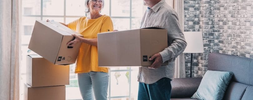 A couple of seniors moving and holding boxes
