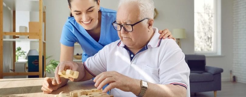Memory care member helping an older adult with a puzzle