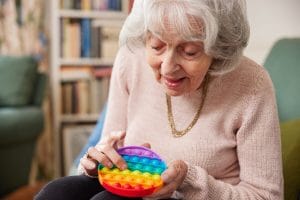 Woman with dementia using a colorful toy for stimulation