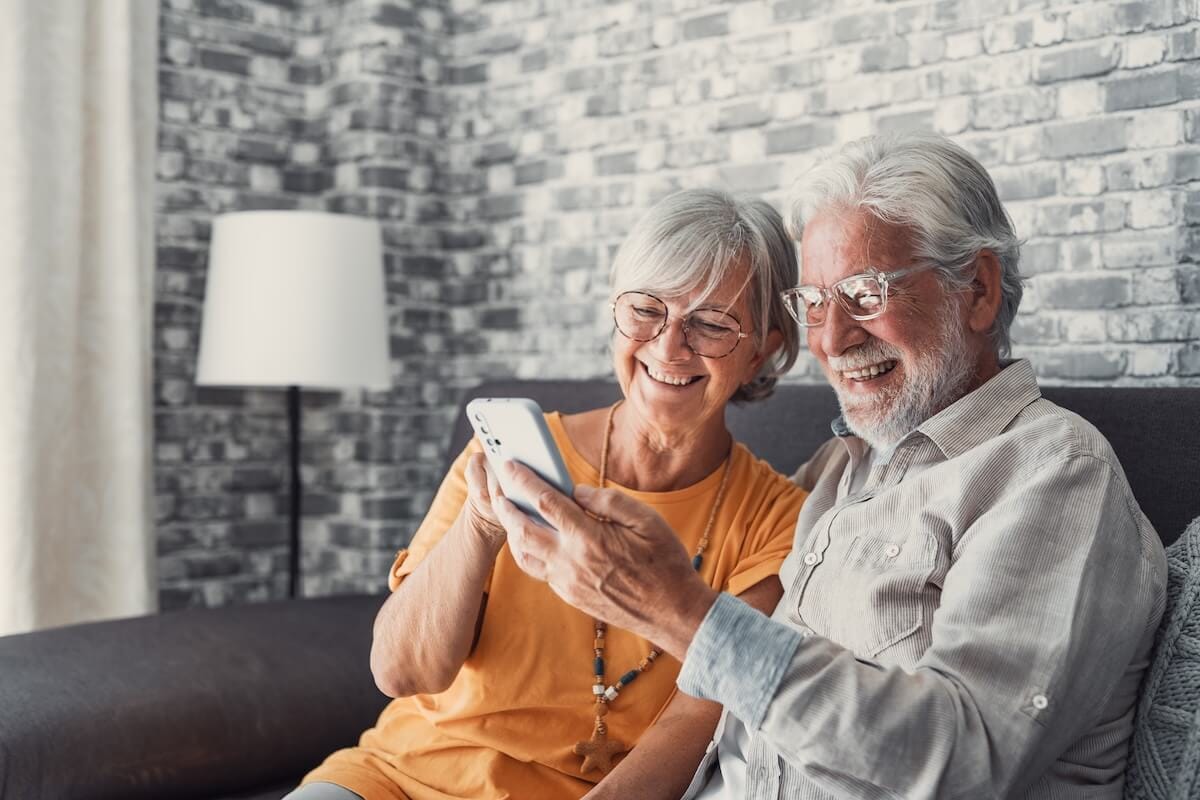 Senior couple communicating with their loved ones through a tablet