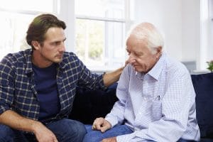 Adult son talking to father about caregiver burnout